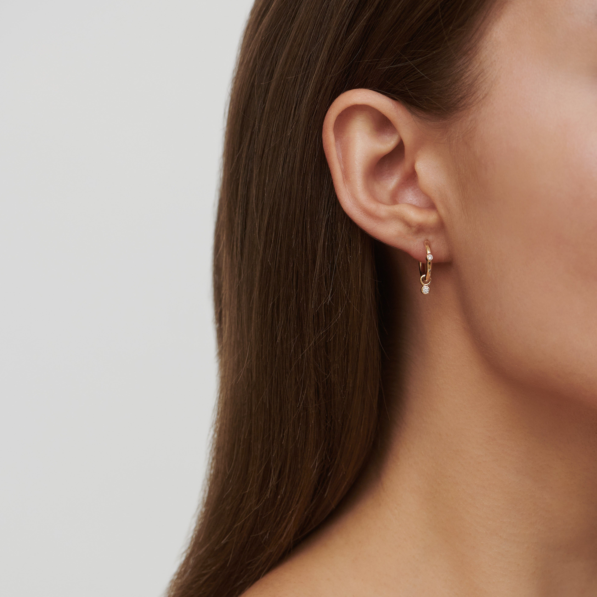 Model bærer Purity Medium Hoop i øret, stylet med et perle ear pendant