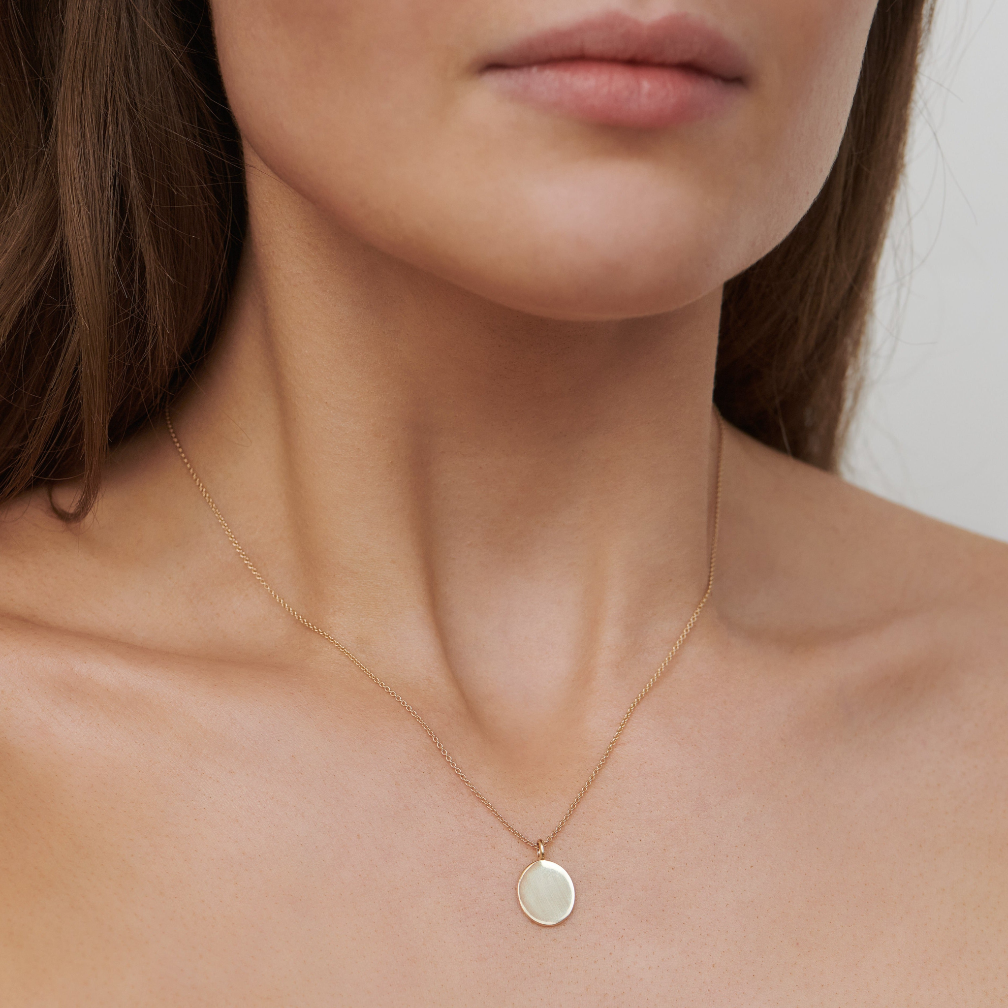 Model bærer Classic Signet Pendant i 14K guld på tynd kæde om halsen