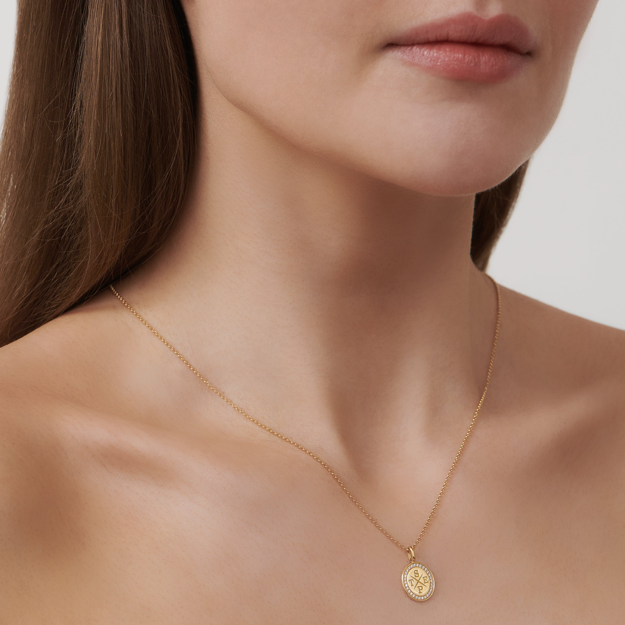 Model bærer Medallion halskæde i 18K guld med indgraveringen STEP