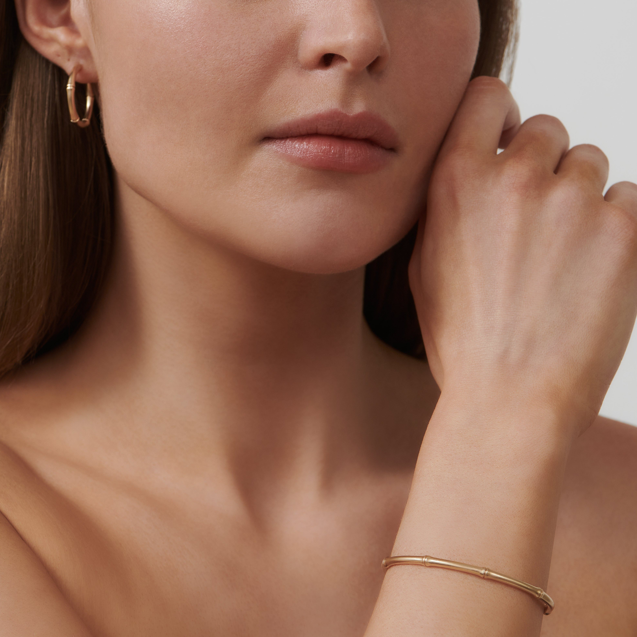 Model bærer Bamboo Cuff og øreringe fra Julie Sandlau i guld