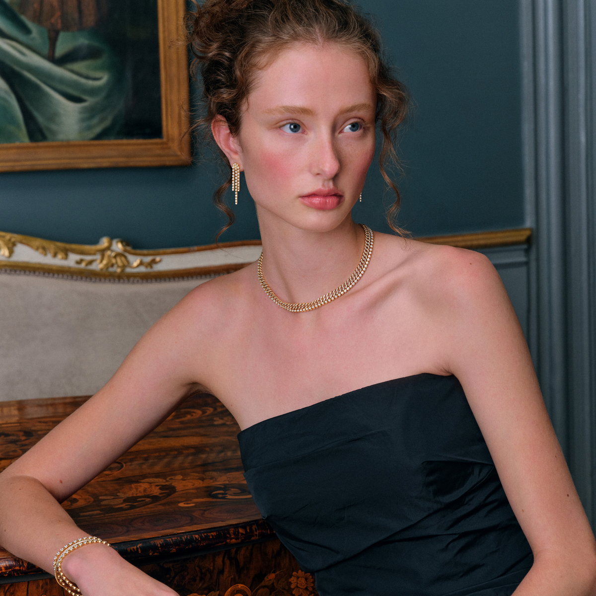 Model bærer Lumi Collier i guld tæt om halsen; øreringen på billedet er ikke en del af dette produkt.