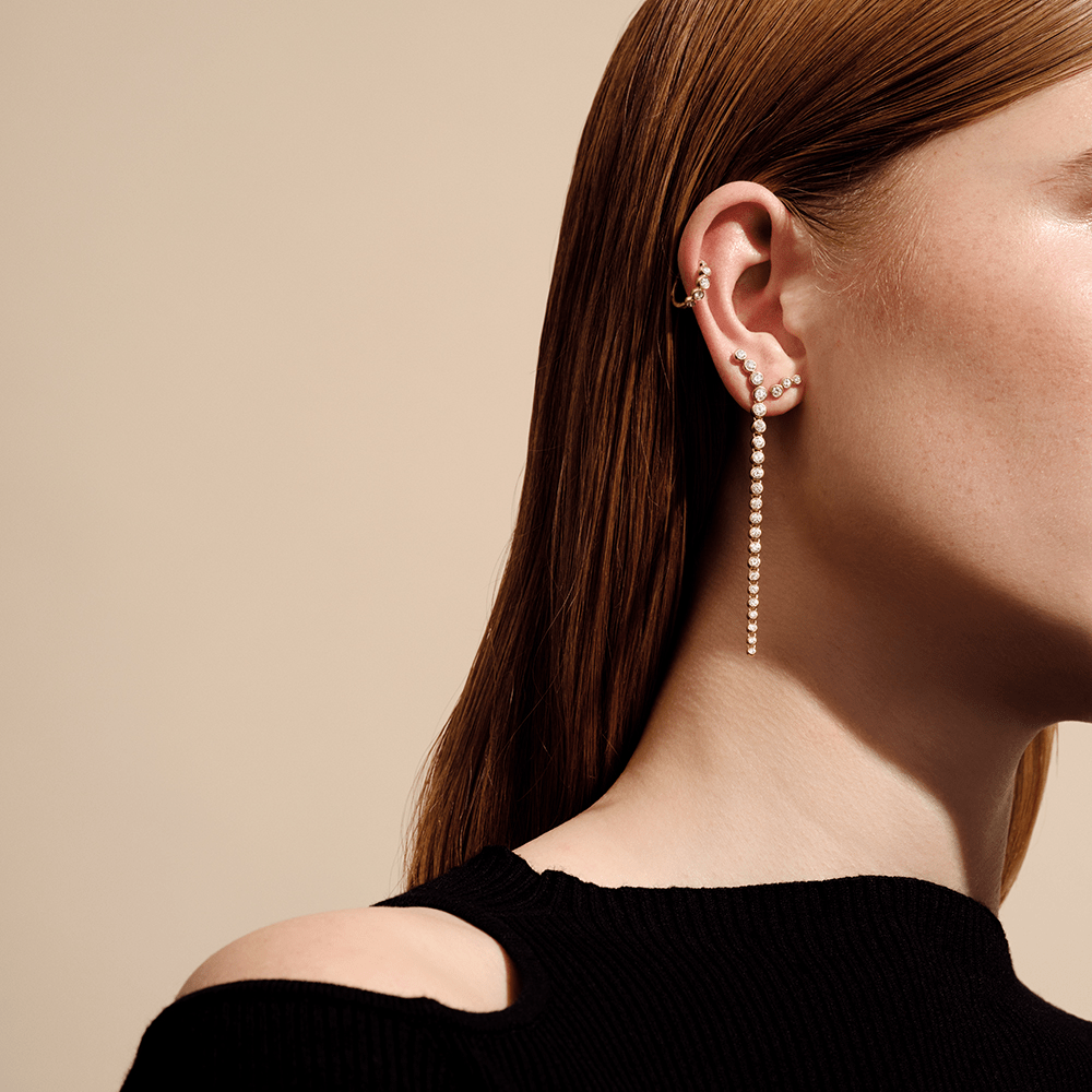 Lumi Chandelier øreringe i guld båret sammen med en diamant-ear cuff