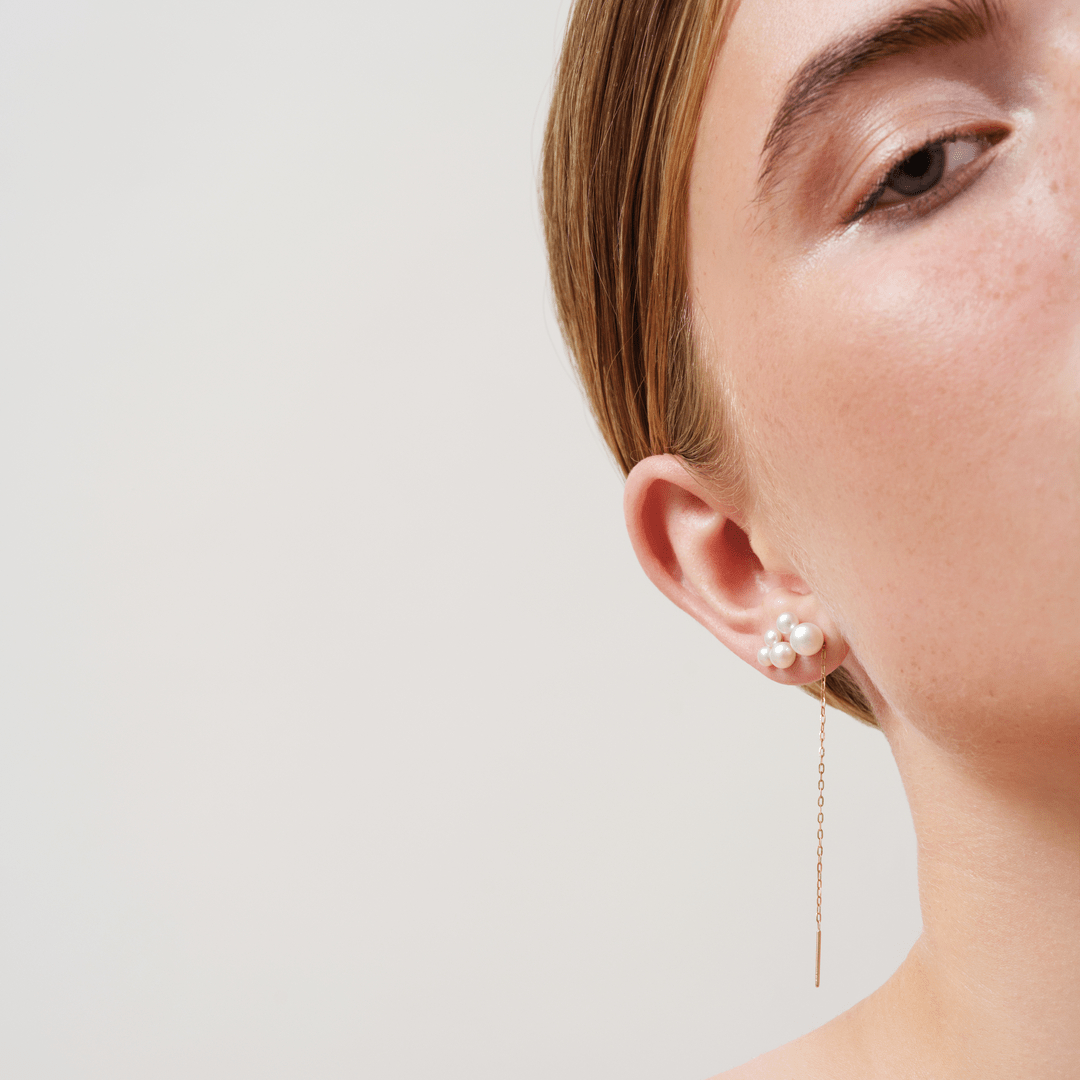 Model bærer Edna and Esther Purity Chain Look med perleklynge i øret