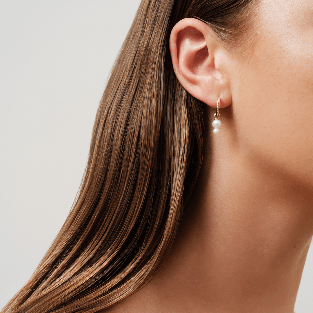 Model bærer Purity and Eden Look øredob i 14K guld med diamant og perler, tæt på øret.