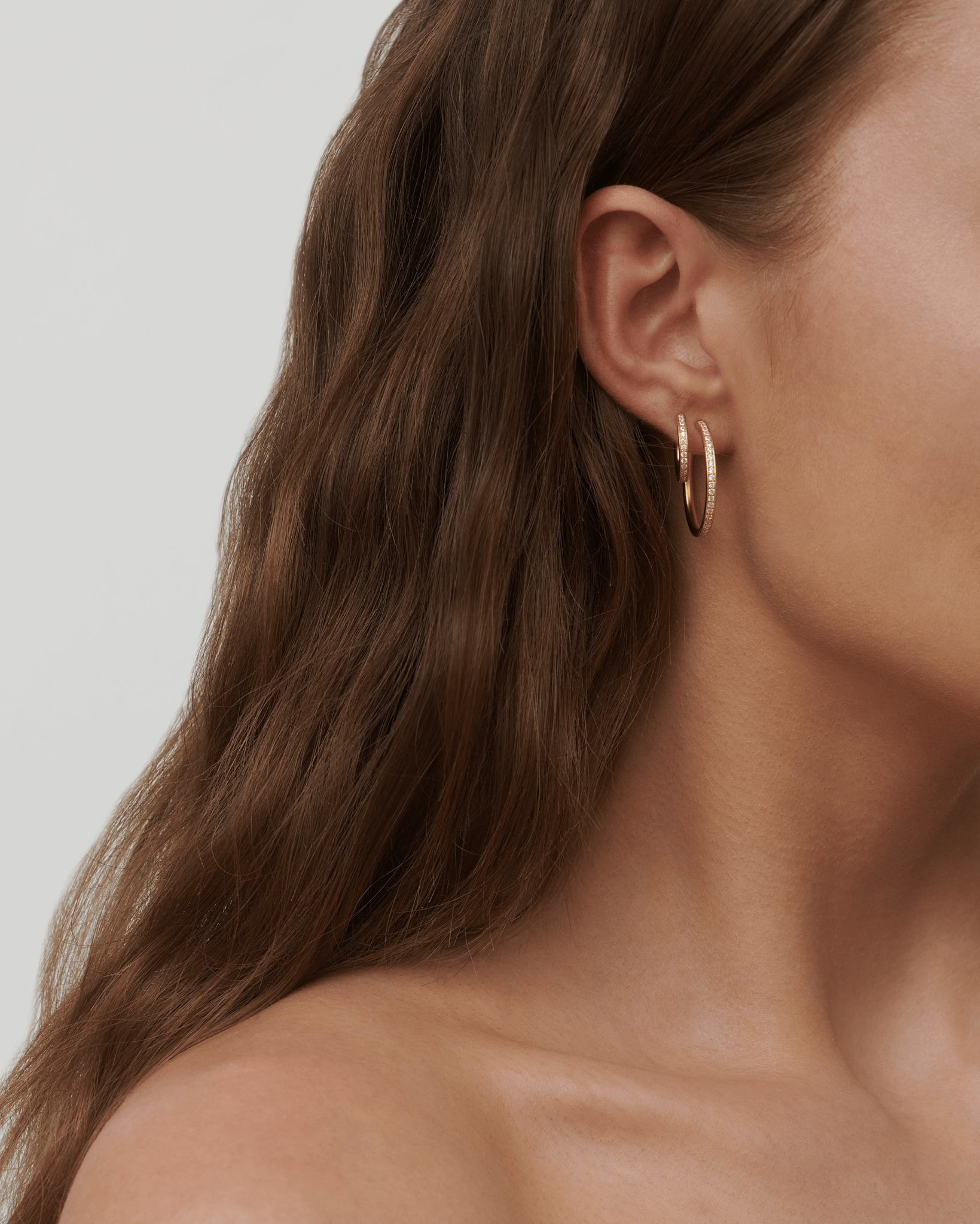 Infinity Hoop Small Earring i forgyldt sølv båret i øret