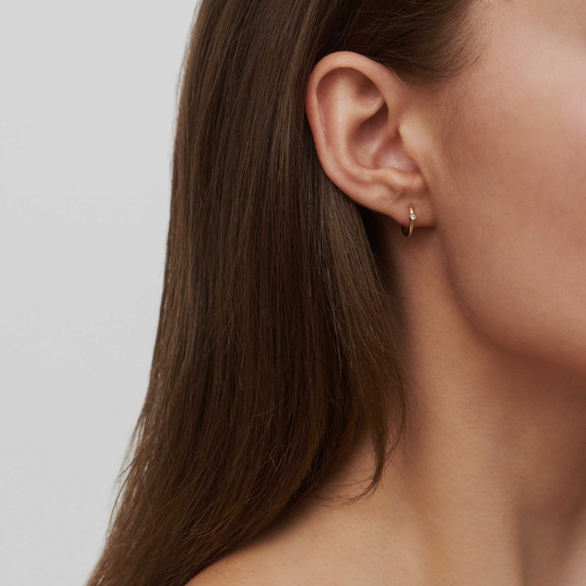 Model bærer Purity Mini Hoop i øret