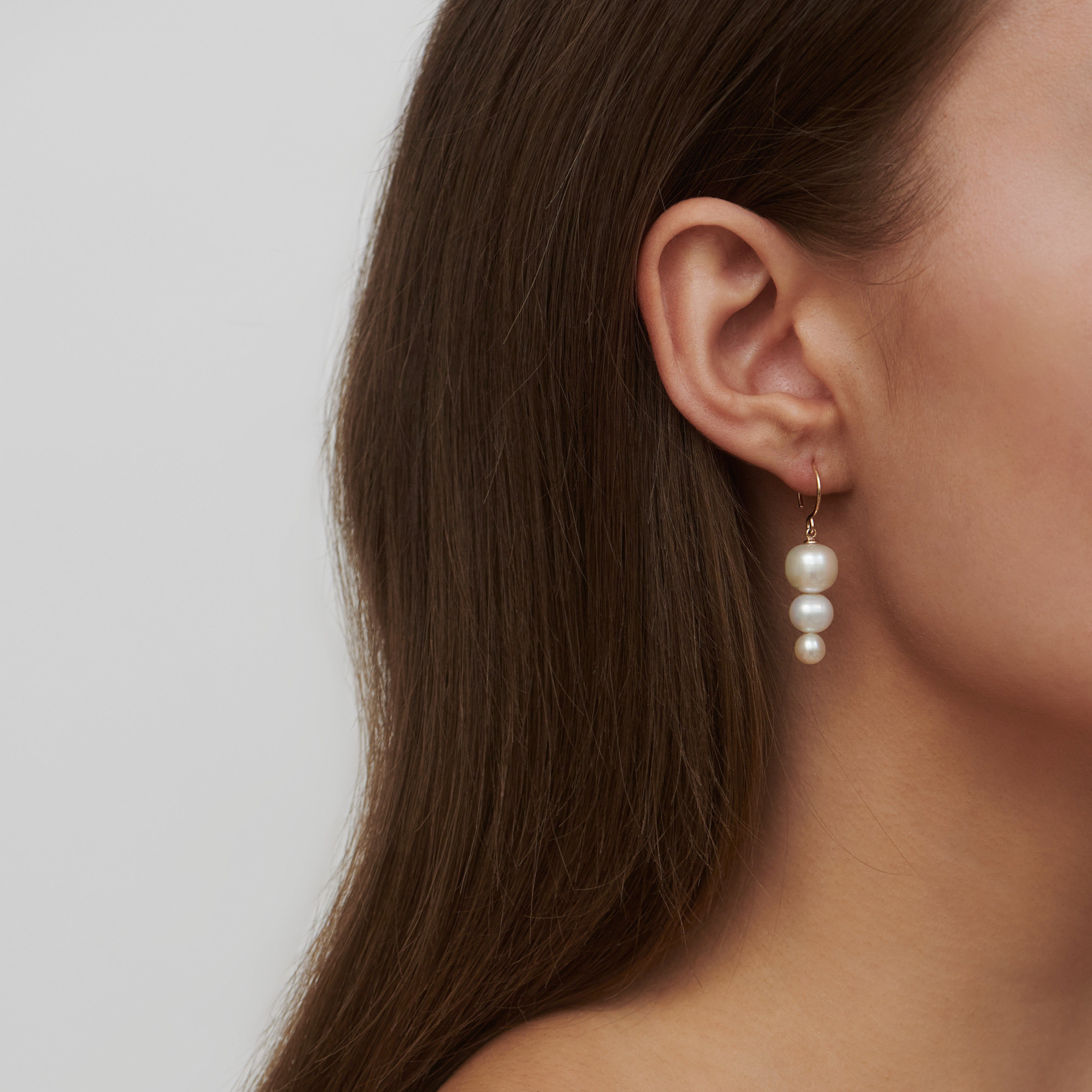 Eden Earring med graduerede hvide perler båret i øret