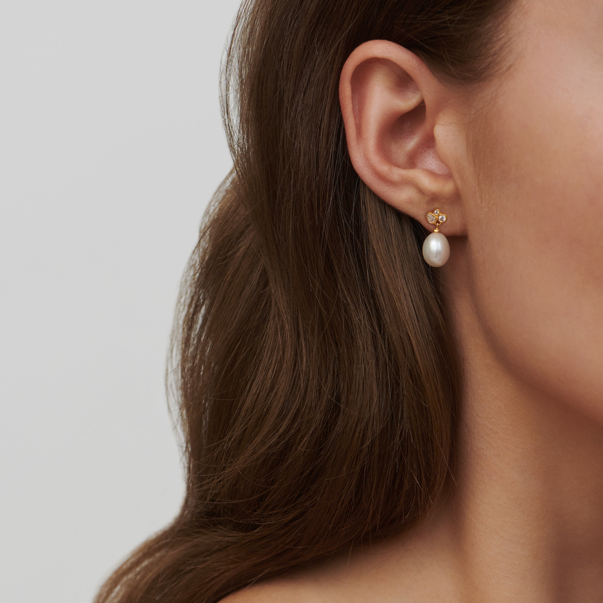 Model bærer Treasure Earrings i øret med ferskvandsperle og zirkonia