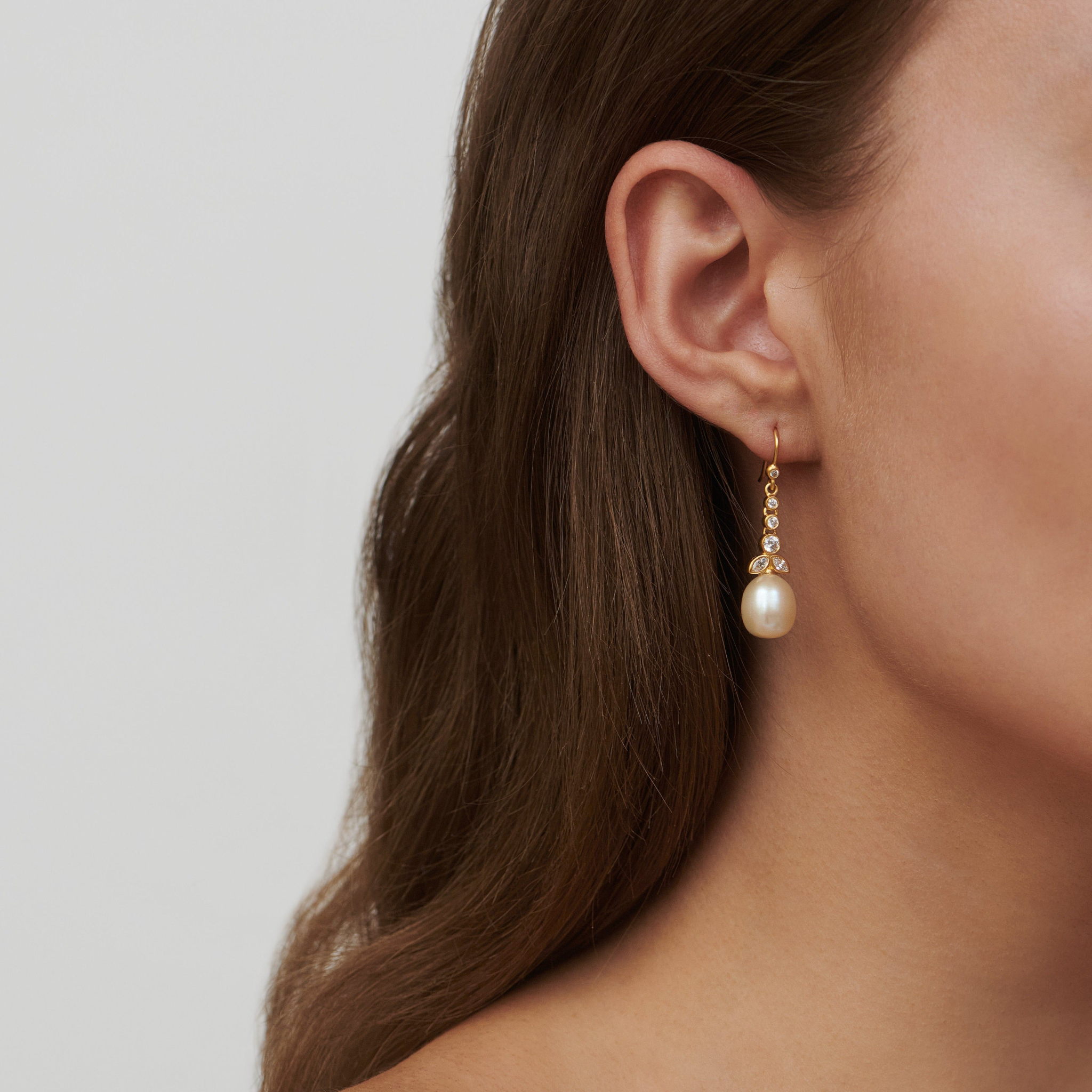 Model bærer Treasure Chandelier ørering med hvid perle og zirkoniaer i forgyldt sølv