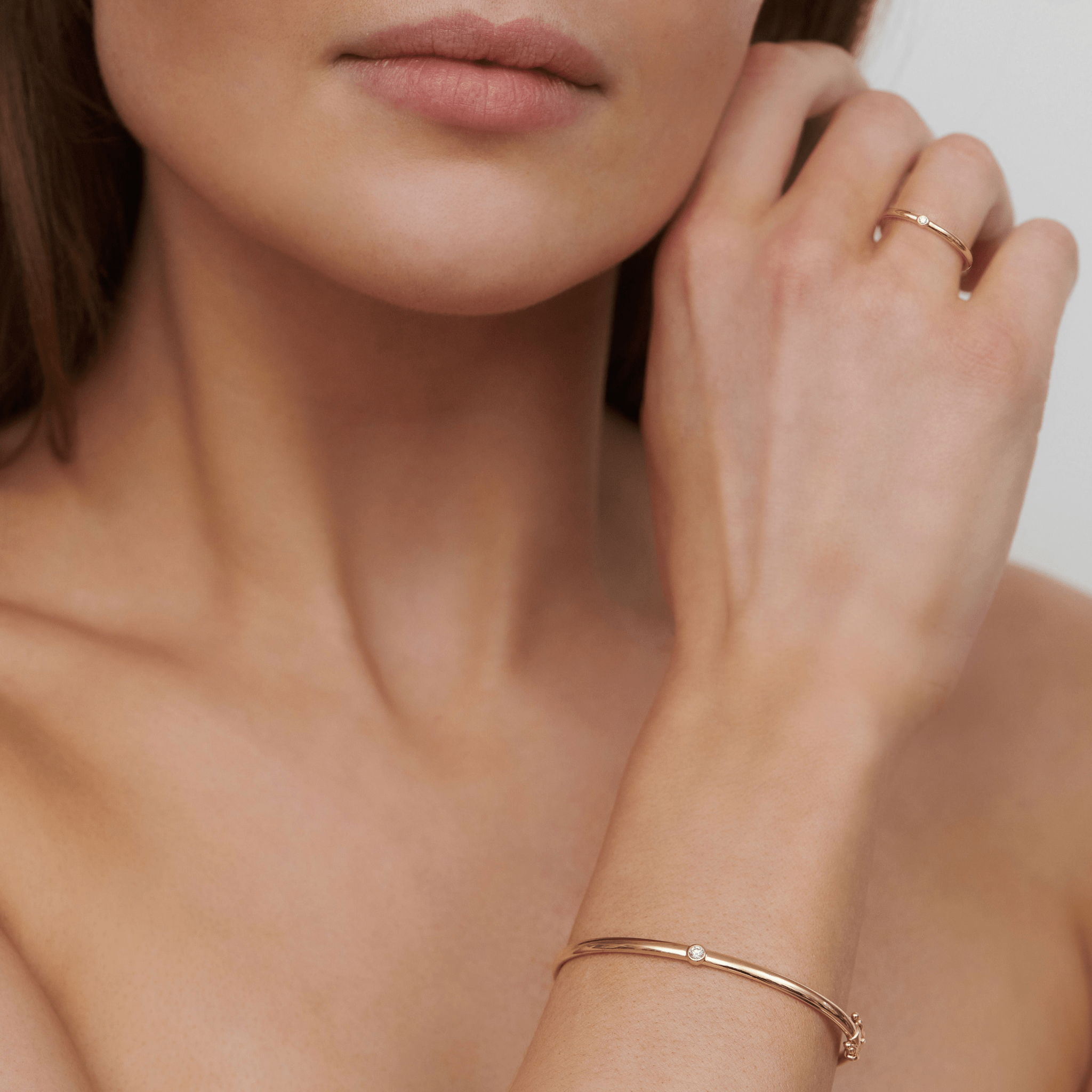 Model bærer Purity armbånd i 14K guld med diamant om håndleddet, sammen med matchende ring