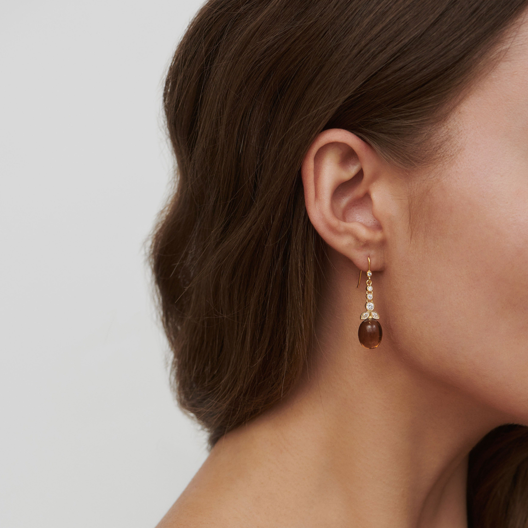 Model bærer Treasure Chandelier ørering med brun dråbeformet sten og zirkoniaer i forgyldt sølv, set fra siden
