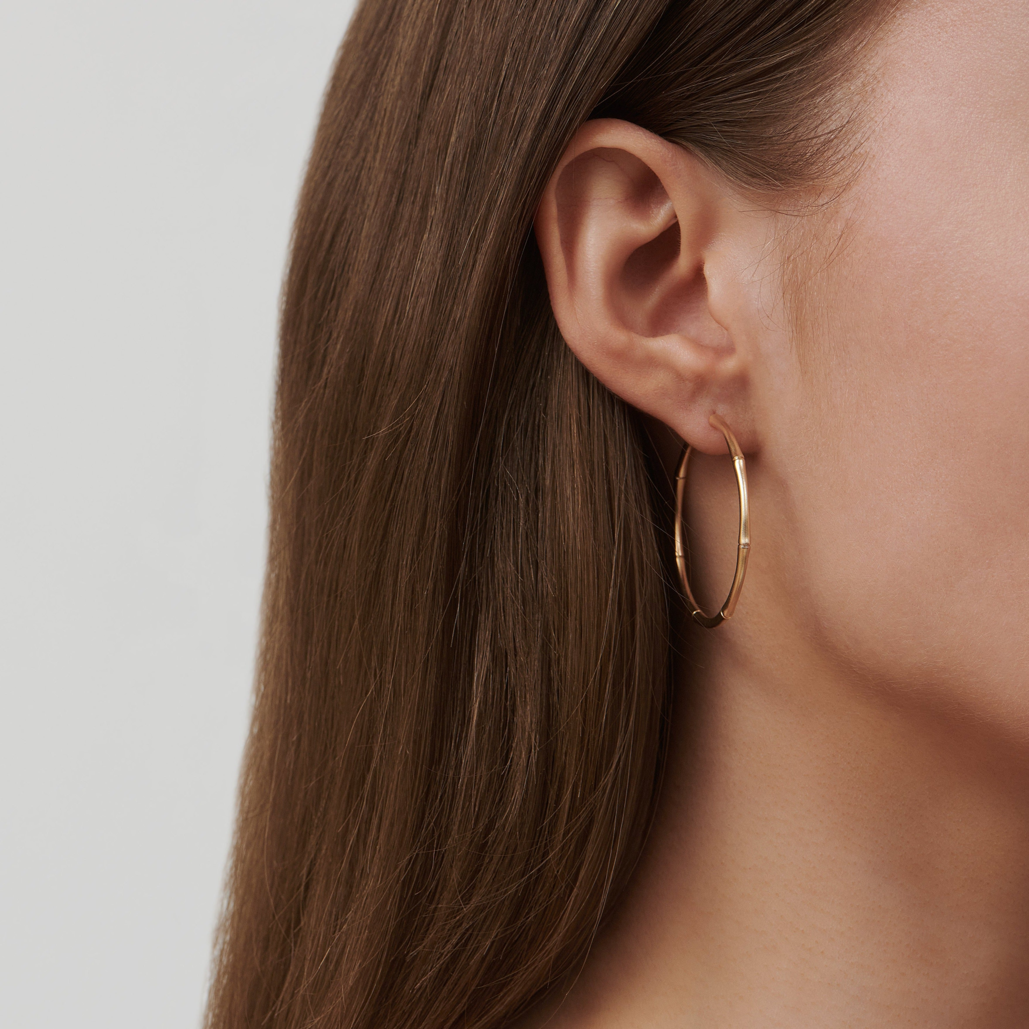 Bamboo Hoops Large i 14K guld båret i øret