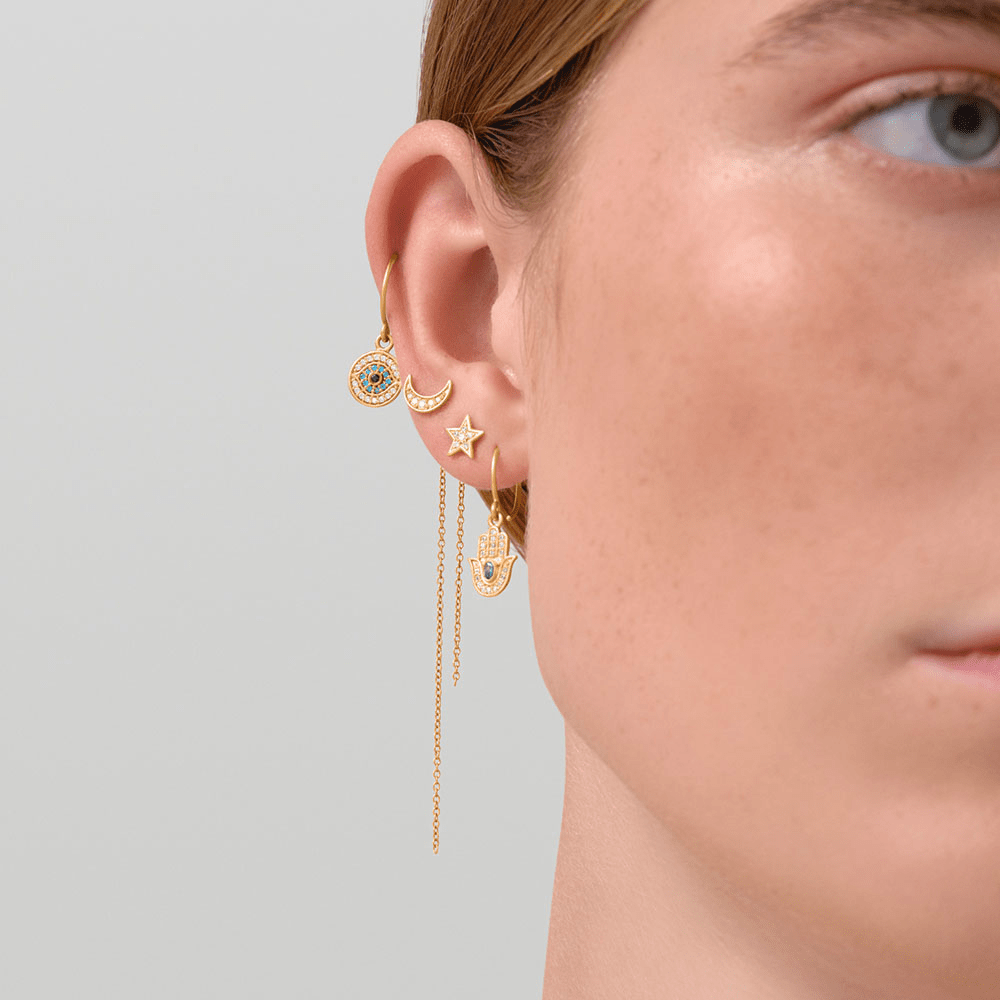 Model bærer Protective Eye ørering i forgyldt sølv stylet i øreparty med flere andre øresmykker