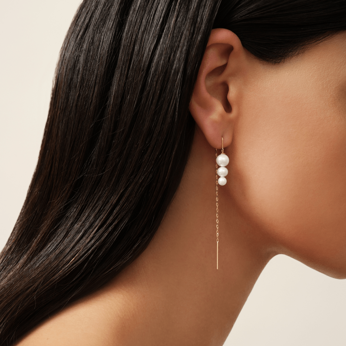 Model bærer Eden Chain Earring med ferskvandsperler og lang guldkæde