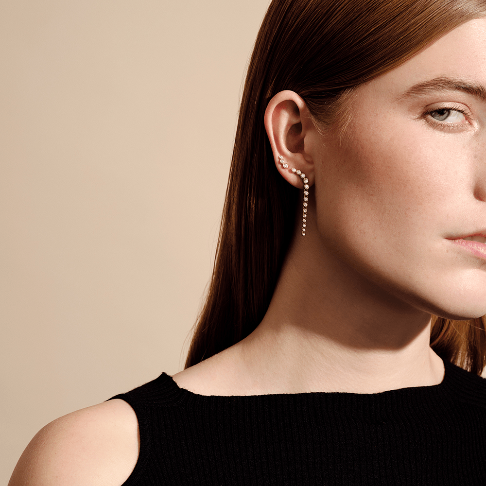 Model i nærportræt med flere øresmykker, herunder diamantbesat ear cuff og kæde