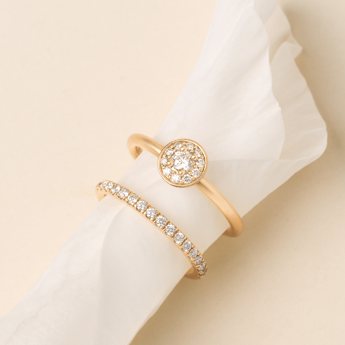 Lulia Halo Ring stacket med diamantring, nærbillede på hvidt stof