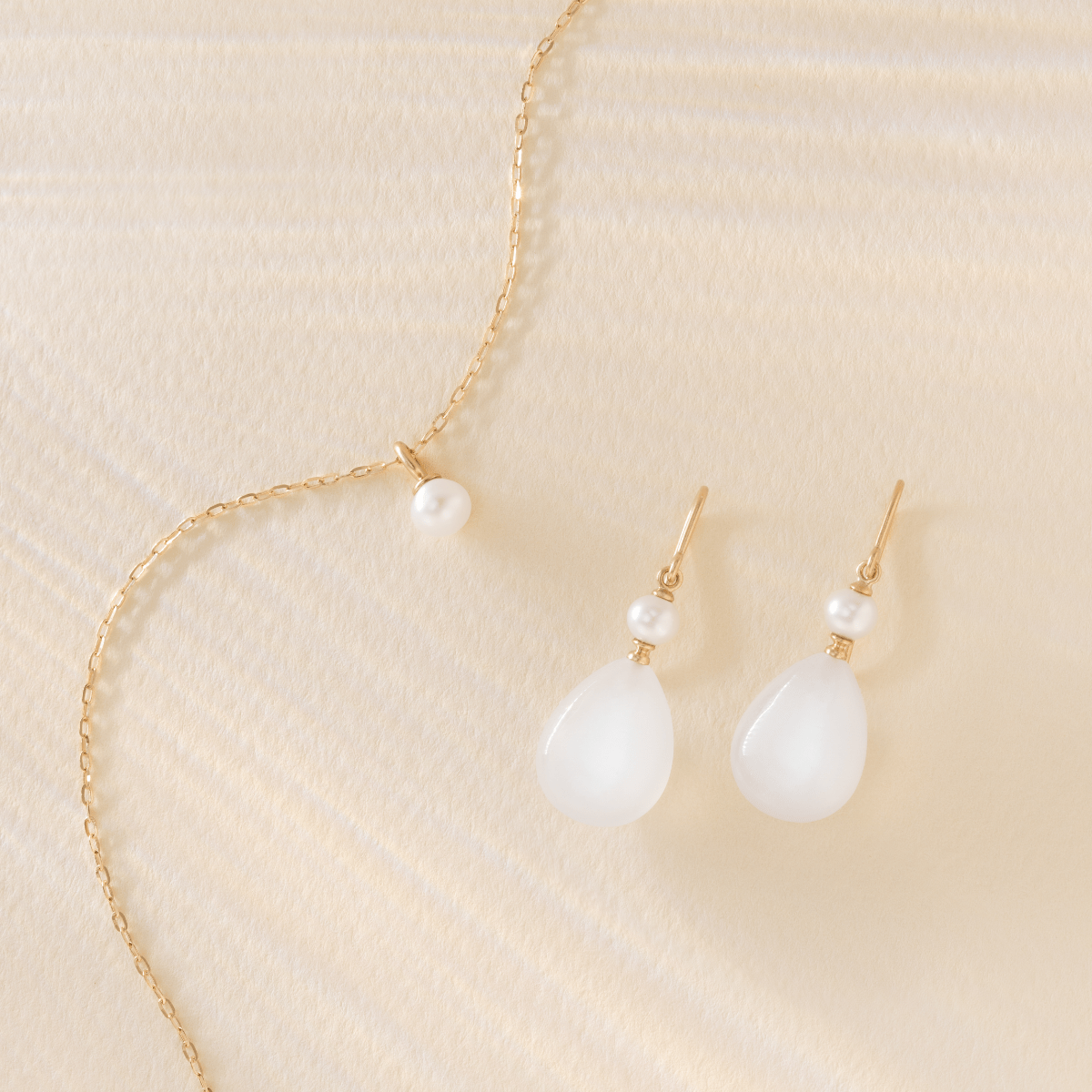 Elina øreringe i 14K guld med White Moonstone, stylet sammen med matchende perlevedhæng i halskæde
