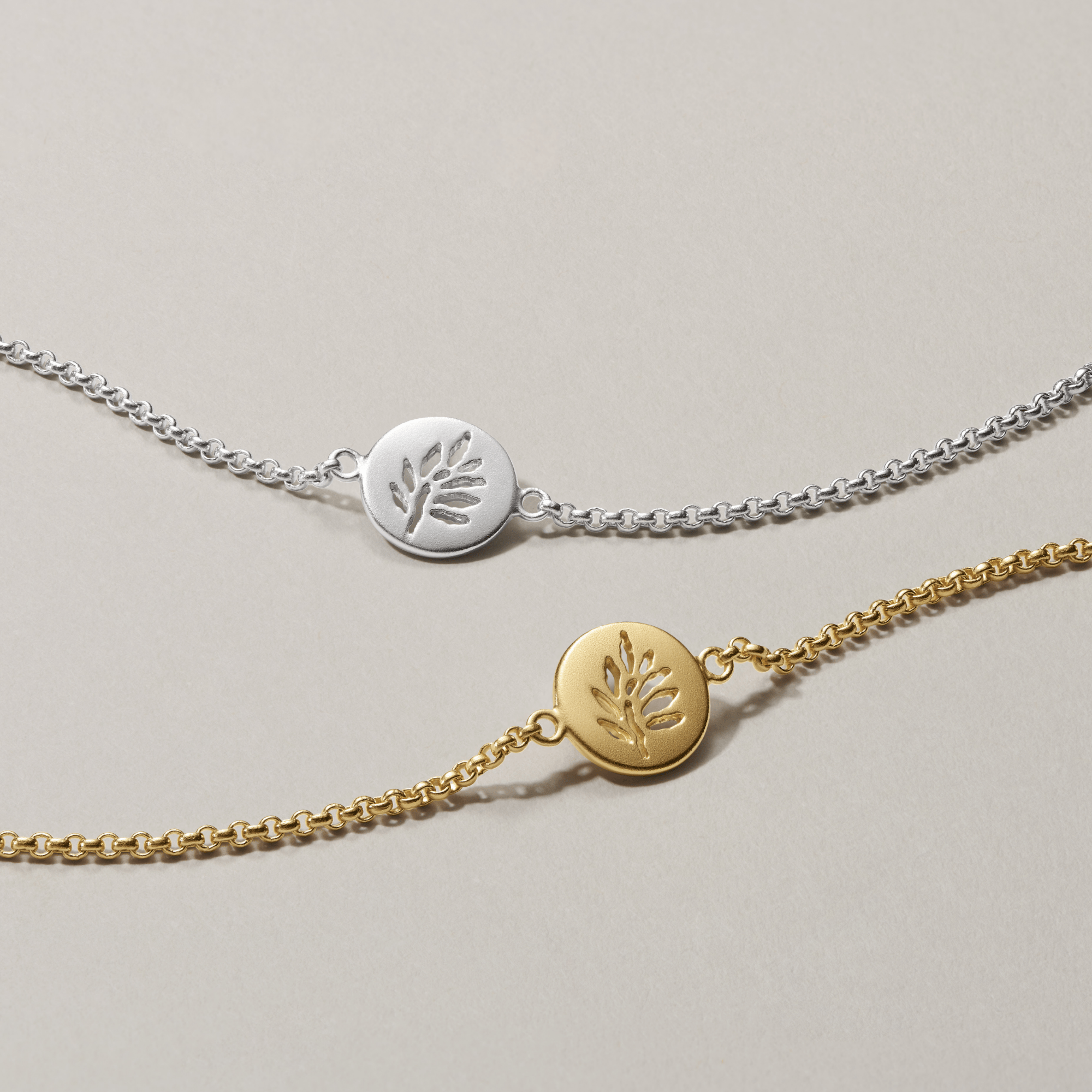 Signature Armbånd vist i både sølv- og forgyldt guld-udgave, side om side.