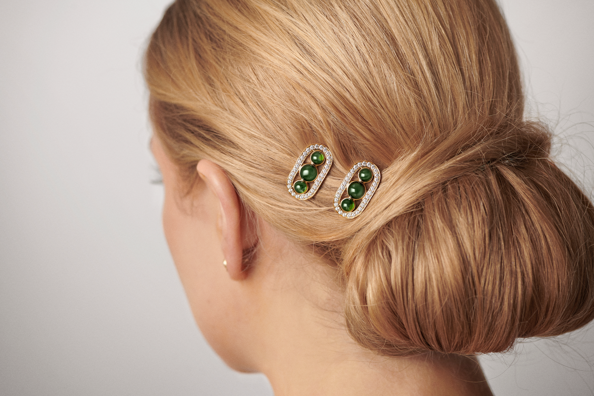 Heritage Hair Clip båret tæt i håret, nærbillede af det gyldne spænde med grønne sten