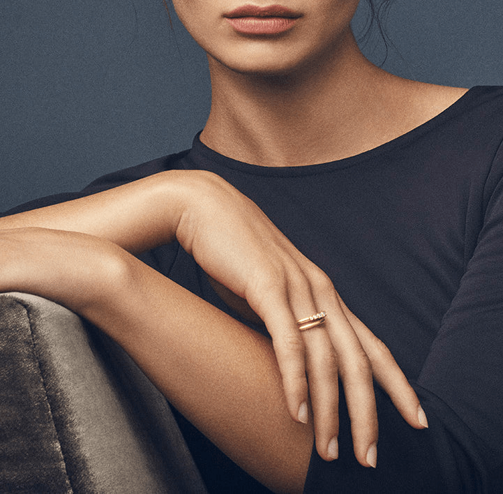 Model bærer Classic ring i guld stacket med en diamantbesat ring